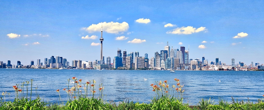 The iconic architecture of Toronto and its financial district seen from the waterfront, representing Ontario's most important economic hub and a benchmark in higher education and research.